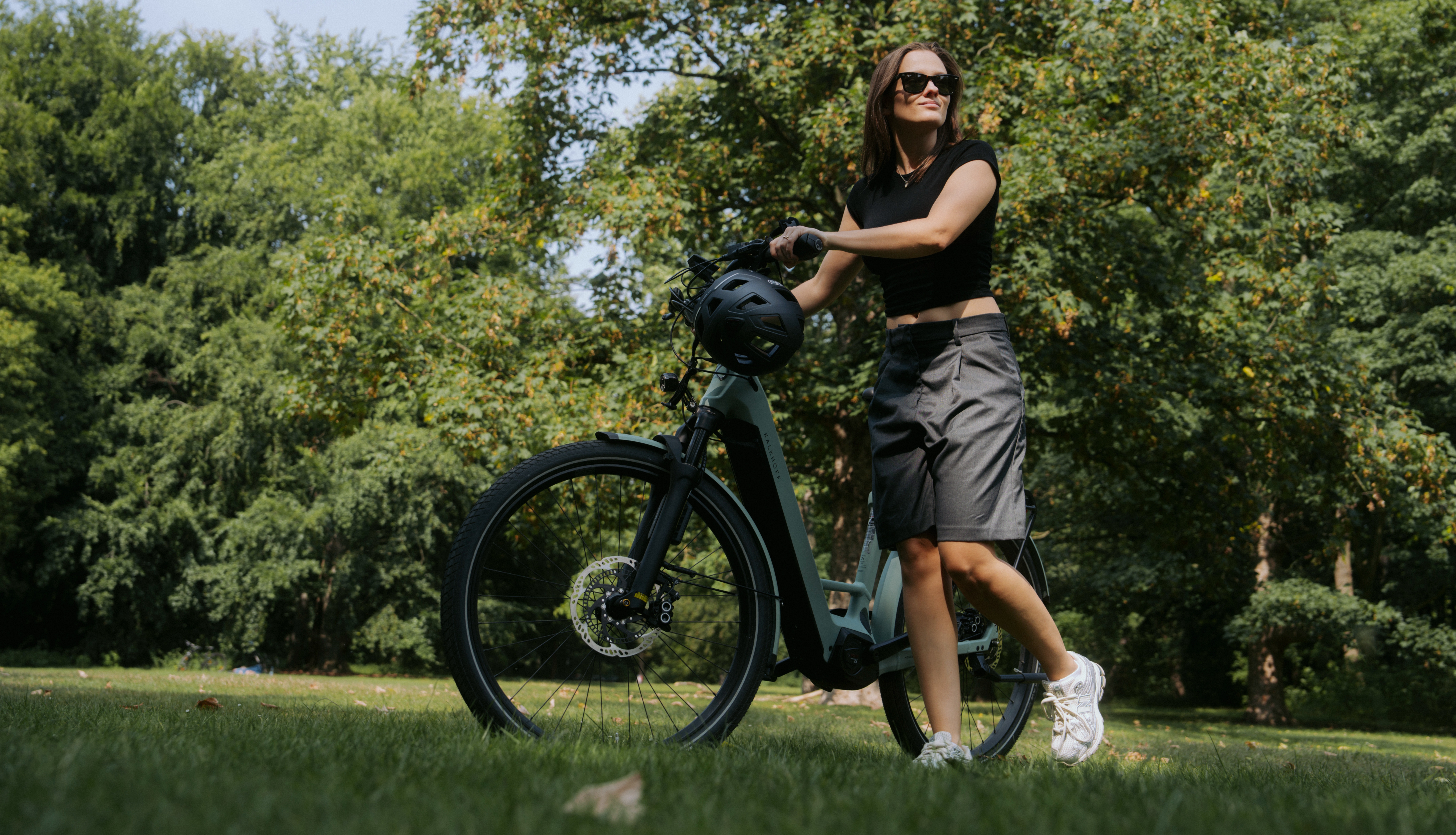 Frau mit E-Bike auf Wiese
