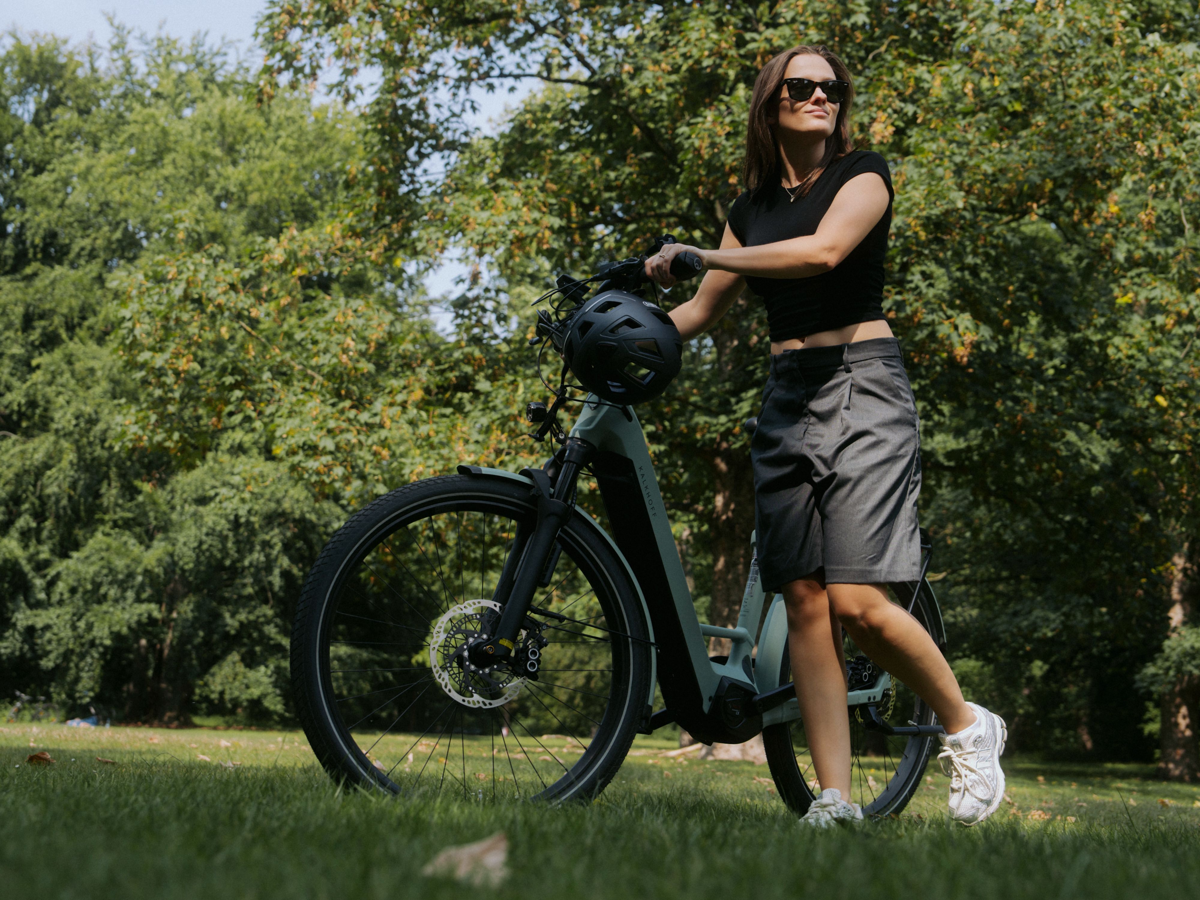 Frau mit E-Bike auf Wiese