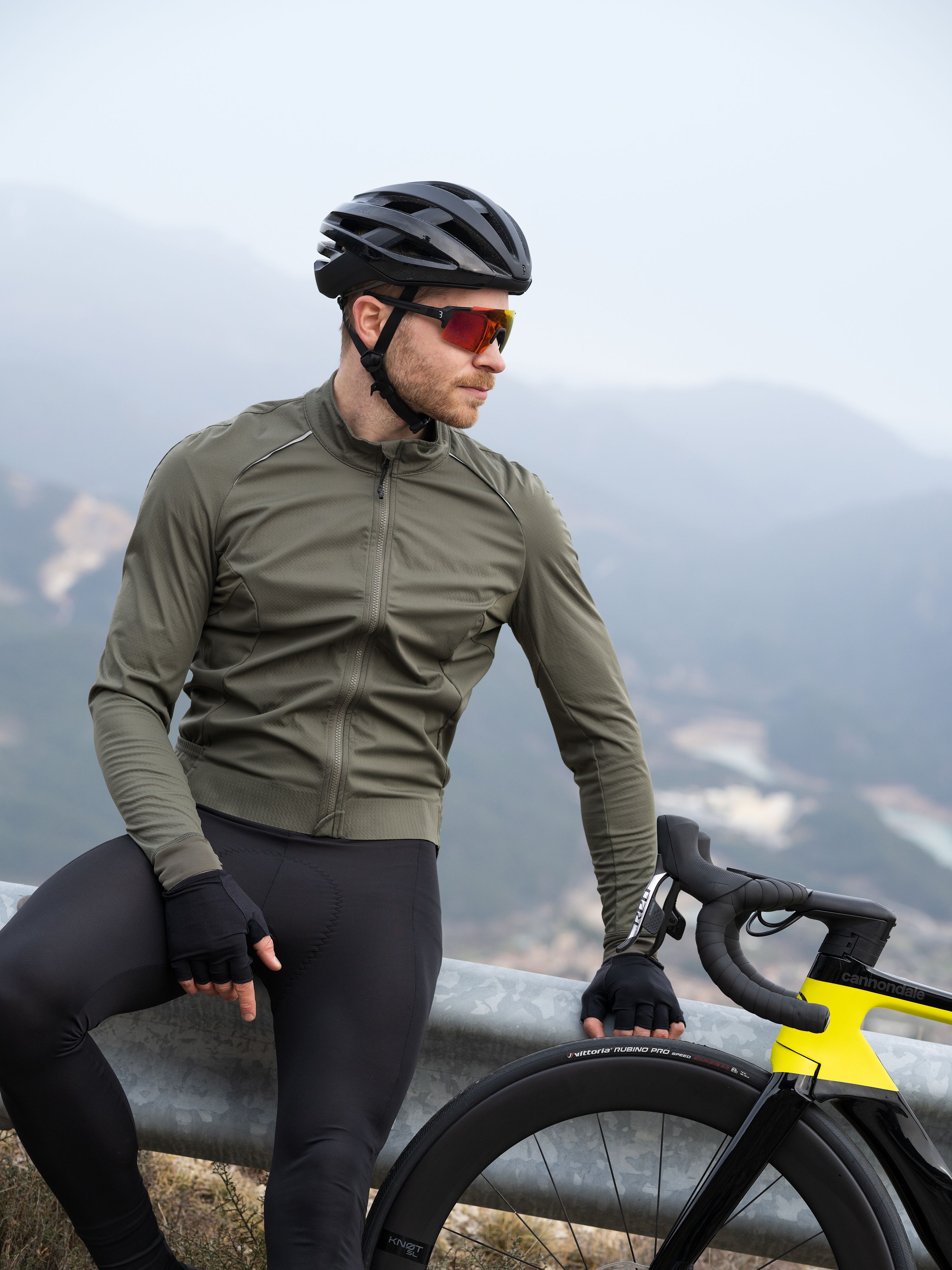 Mann mit Rennrad, im Hintergrund Berge.