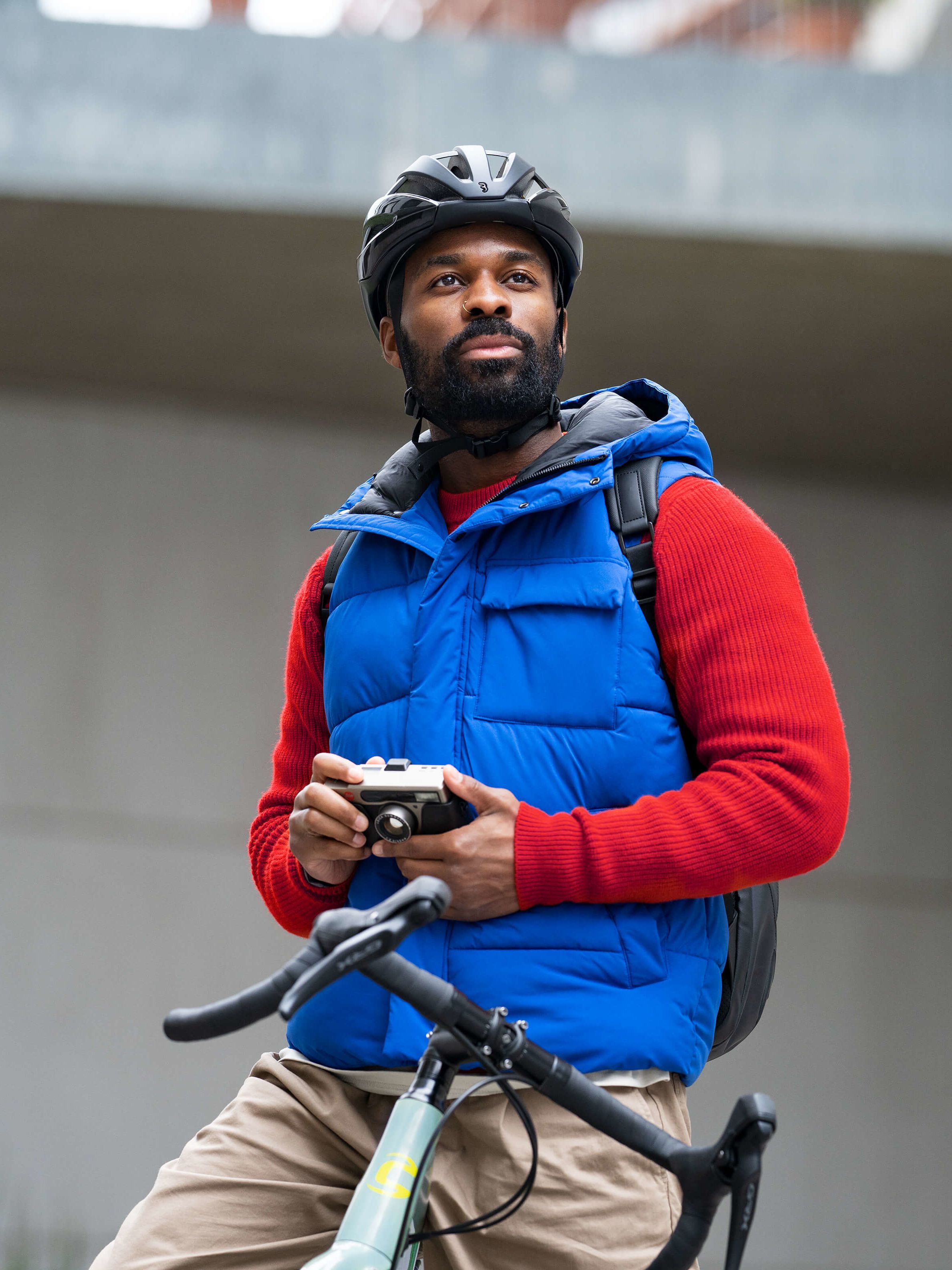 Mann mit Kamera in der Hand auf seinem Fahrrad.