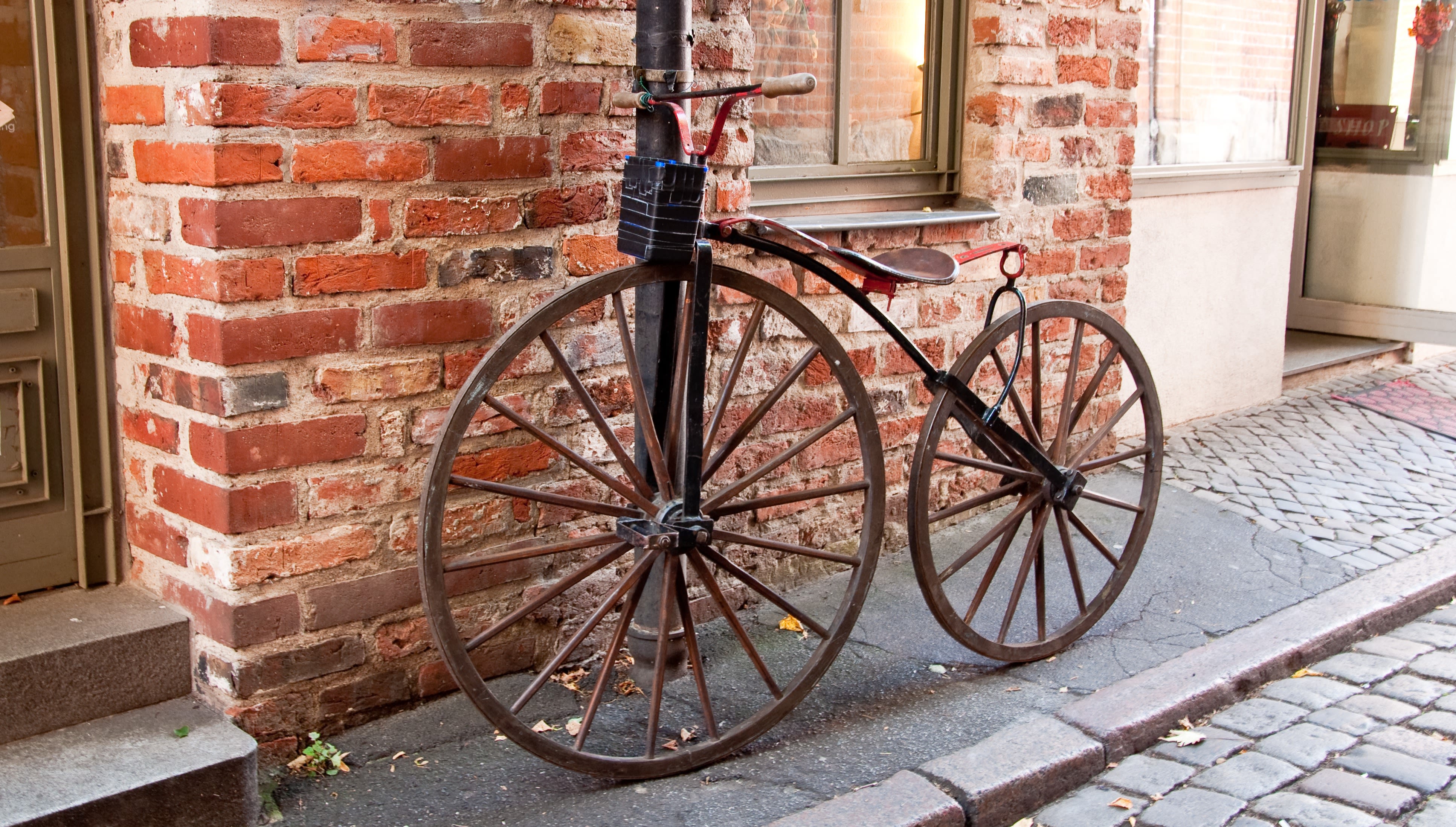 Velociped vor einer Steinwand