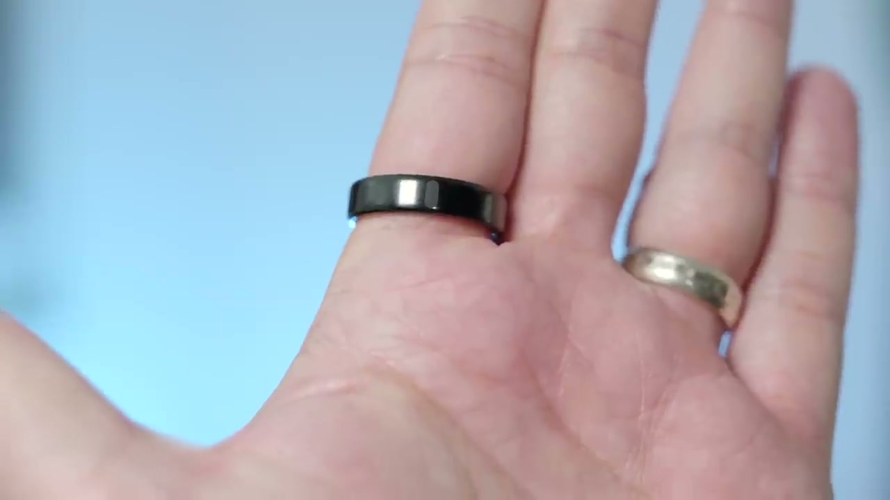 Reviewer%20Cam%20Bunton%20holding%20the%20Oura%20Ring%205%2C%20comparing%20its%20slim%20profile%20to%20the%20older%2C%20chunkier%20model.