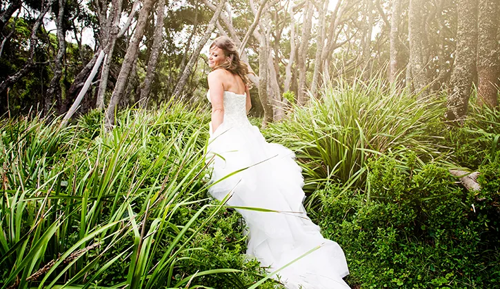 Bride walking through long grass