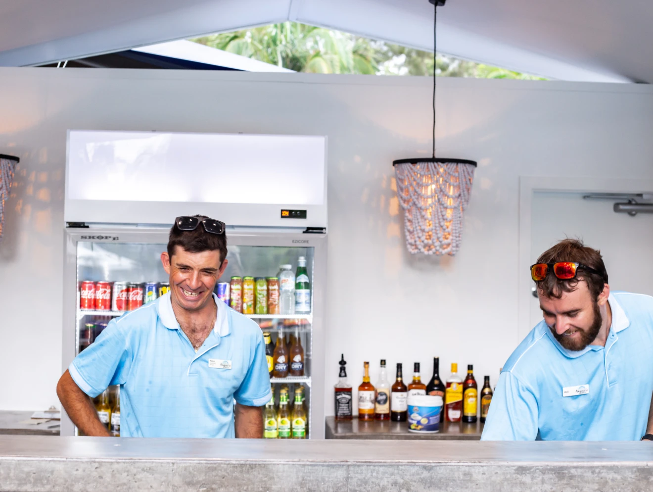 Two male employees working at the pool bar