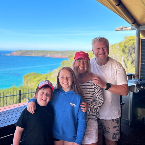Meg Law, author, standing with her husband and 2 children.