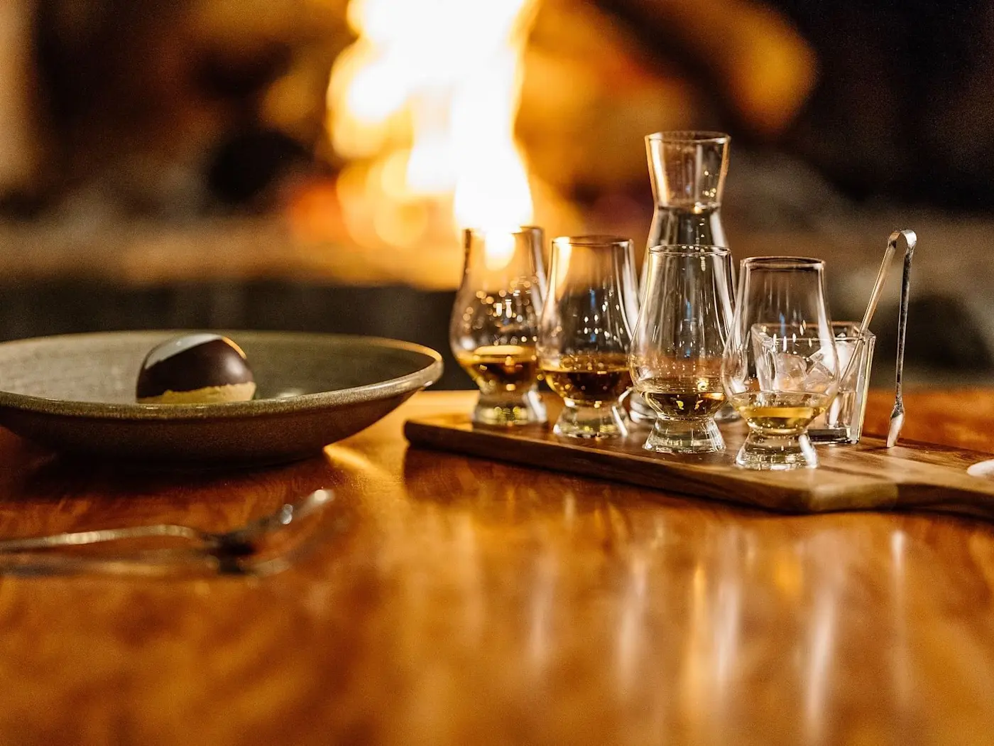 Glasses presented for wine tasting by a fireplace at Freycinet Lodge