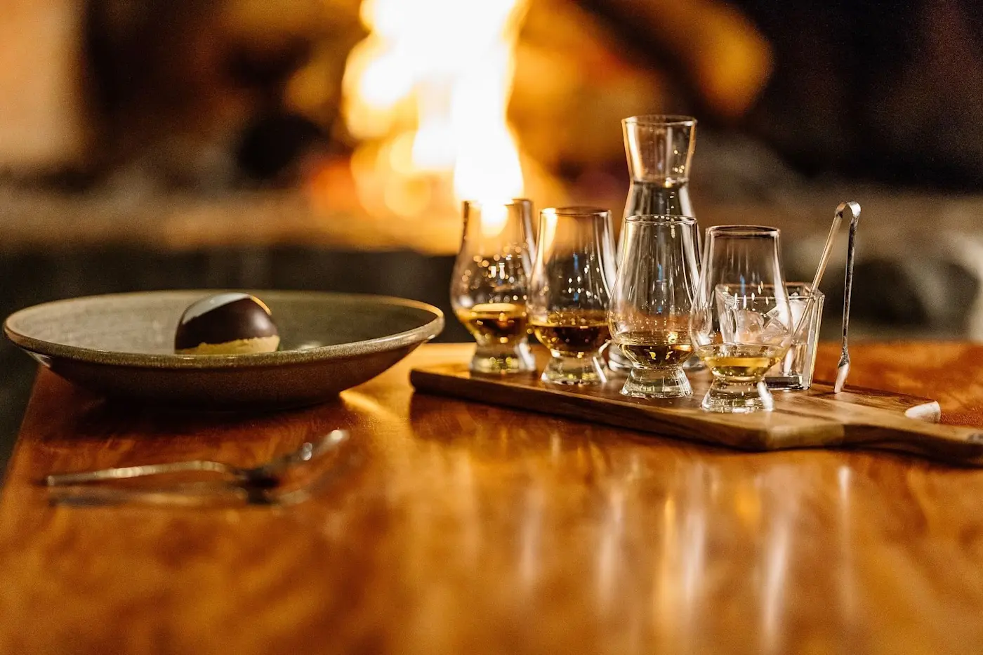 Glasses presented for wine tasting by a fireplace at Freycinet Lodge