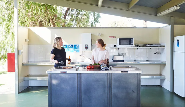 Two women having a BBQ in the camp kitchen at Victor Harbor