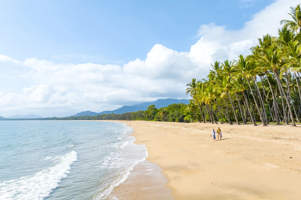 Couple walking on Palm Cove beach 