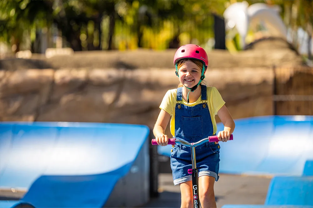 Going going around a pump track on her scooter