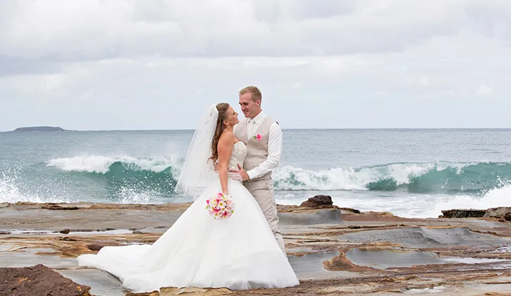 Bride and groom by the ocean