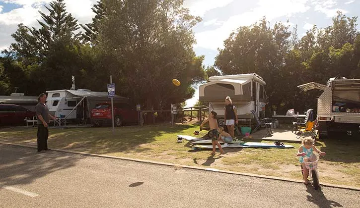 Family playing near their caravan at Tathra Beachfront Holiday Park