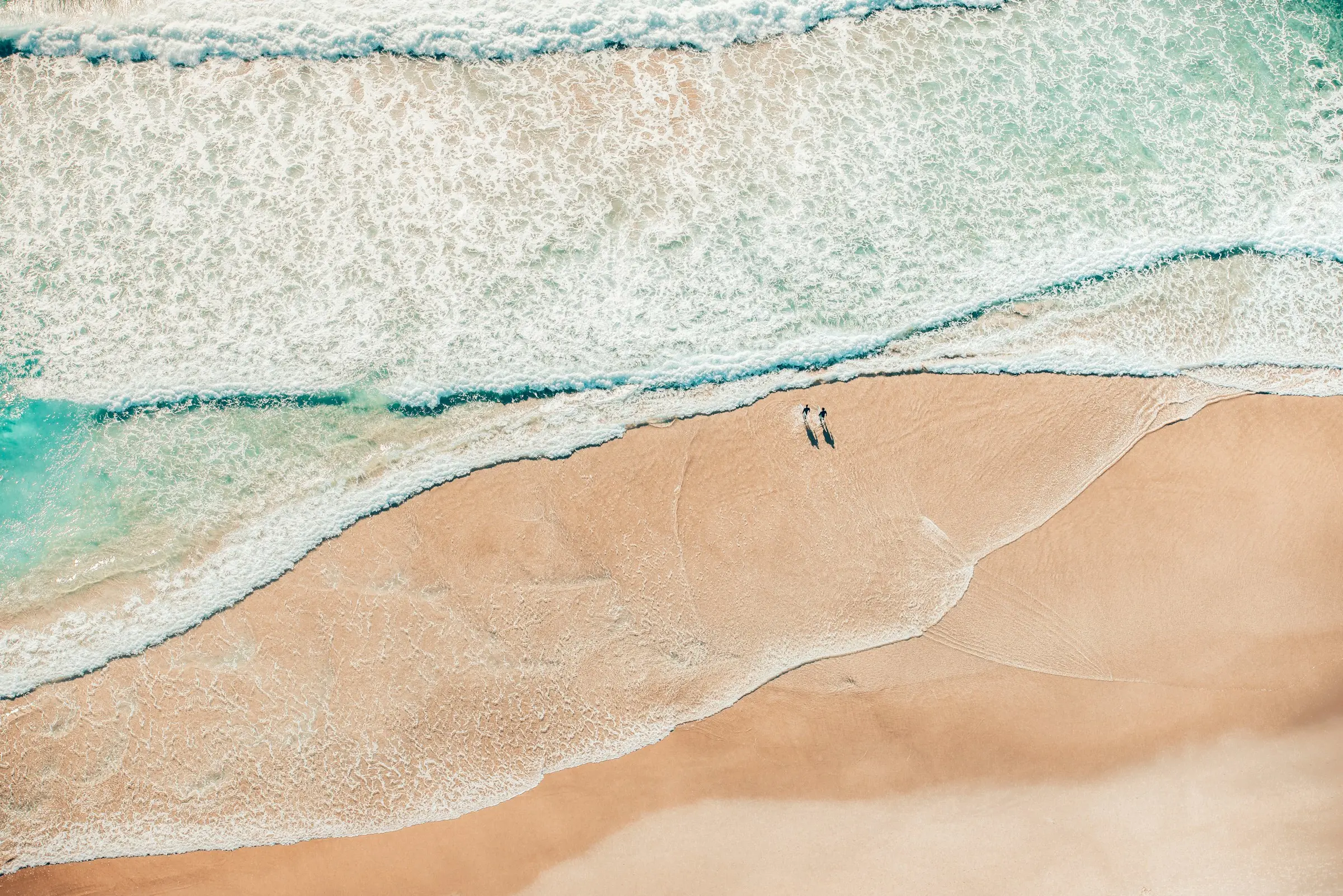 Two people walking on the beach