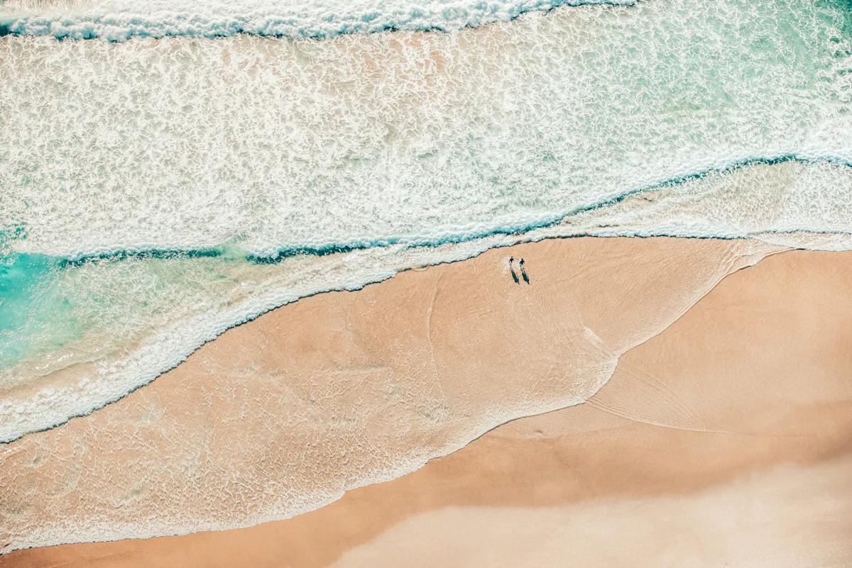 Two people walking on the beach
