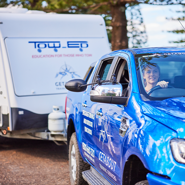 Woman driving a ute towing a caravan