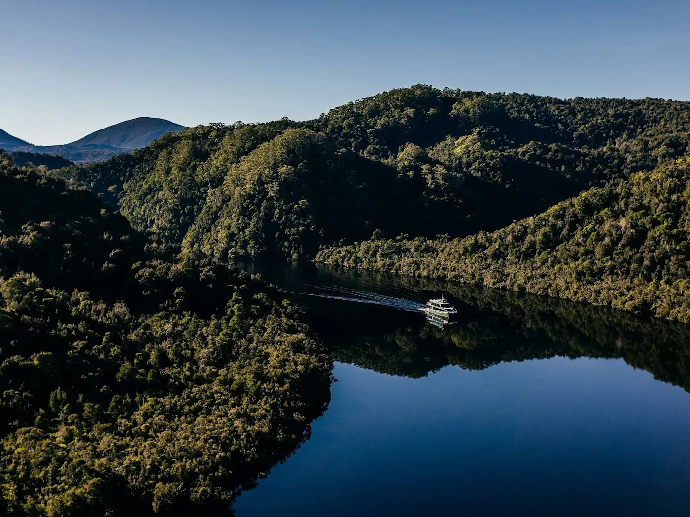 Aerial view of Cruise ship sailing at Gordon River near the Strahan Village