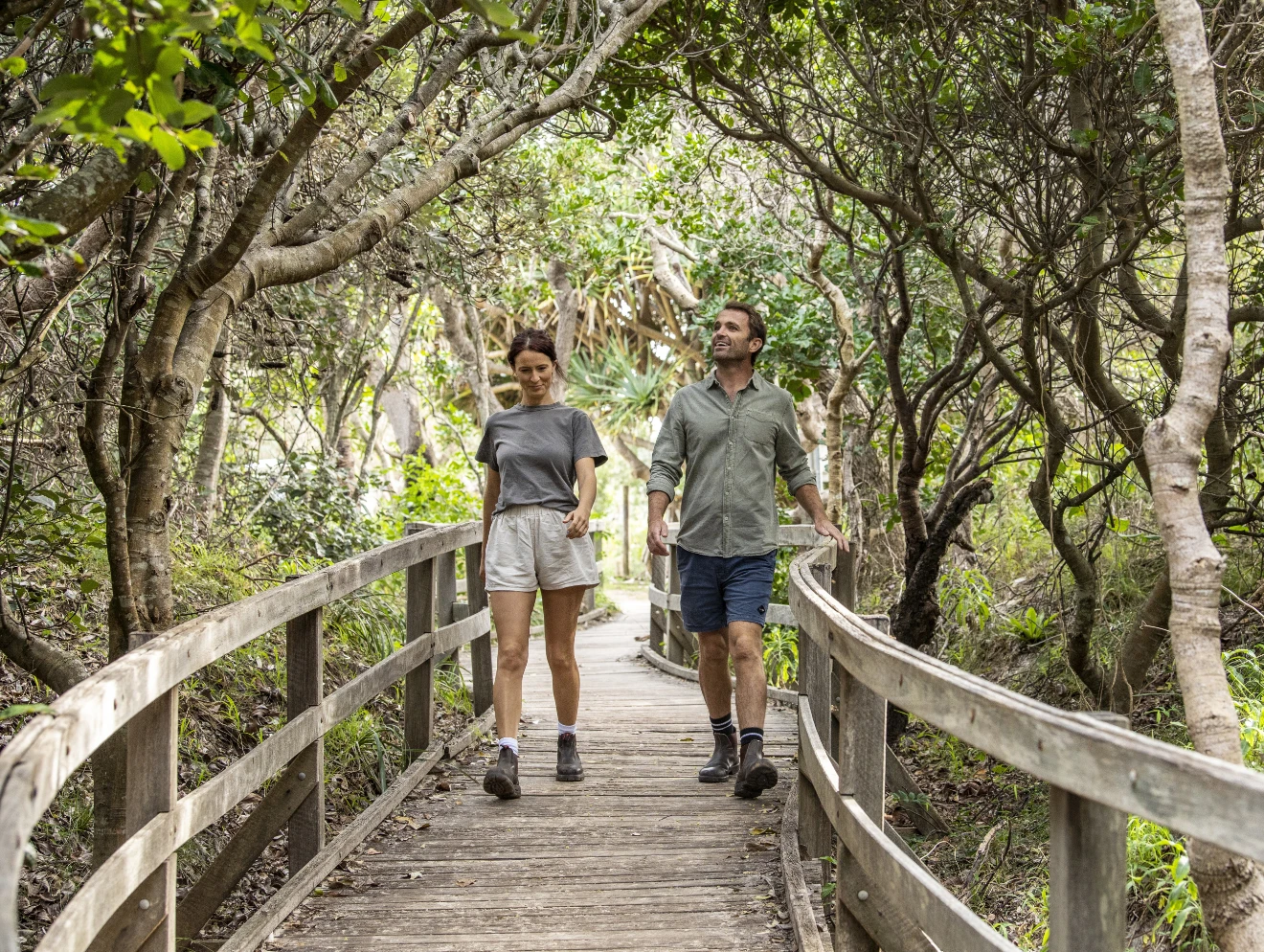 Two people walking along the boardwalk on the Yuraygir Coastal track