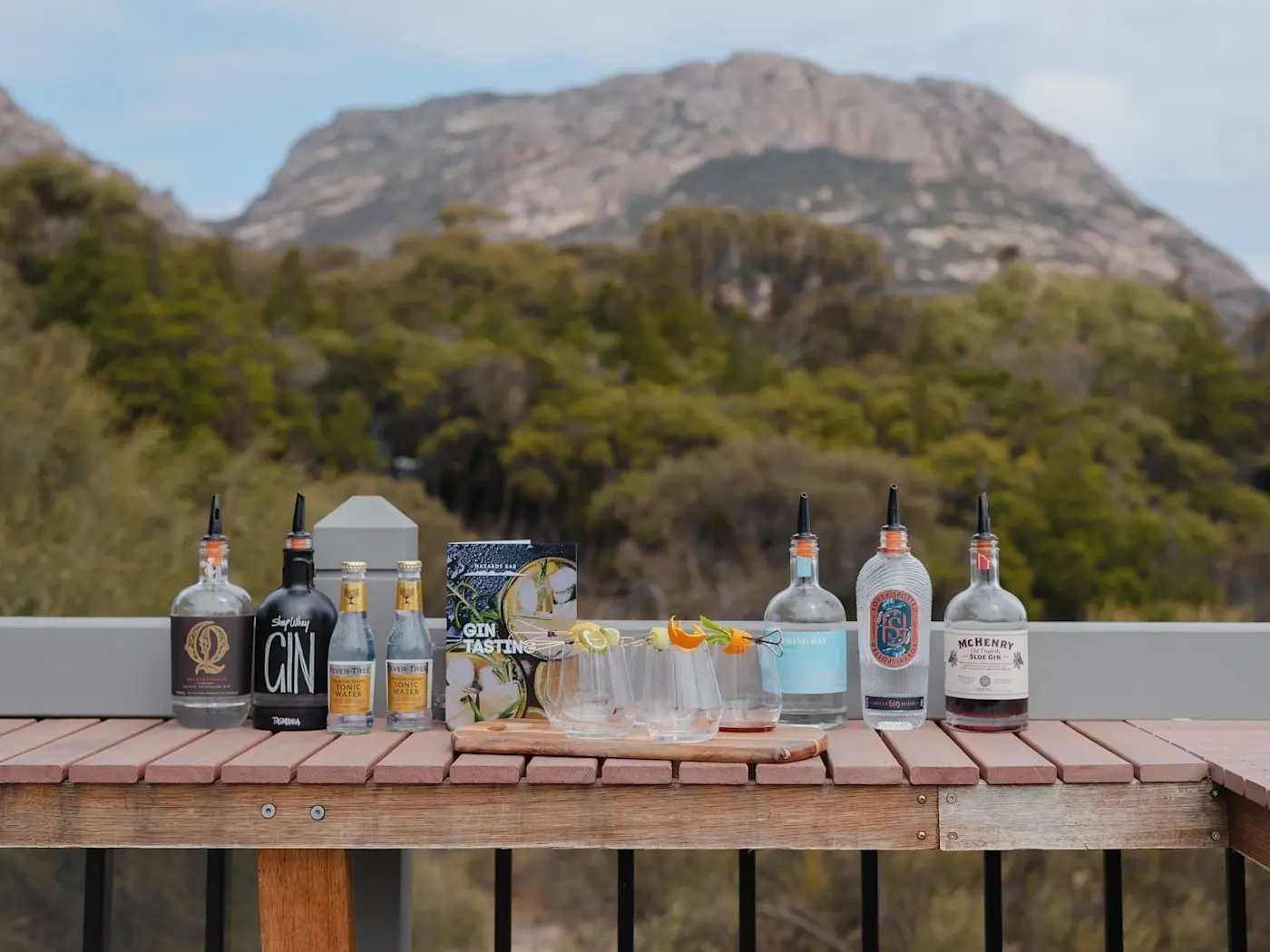Liquor bottles placed on a table with a mountain backdrop near Freycinet Lodge