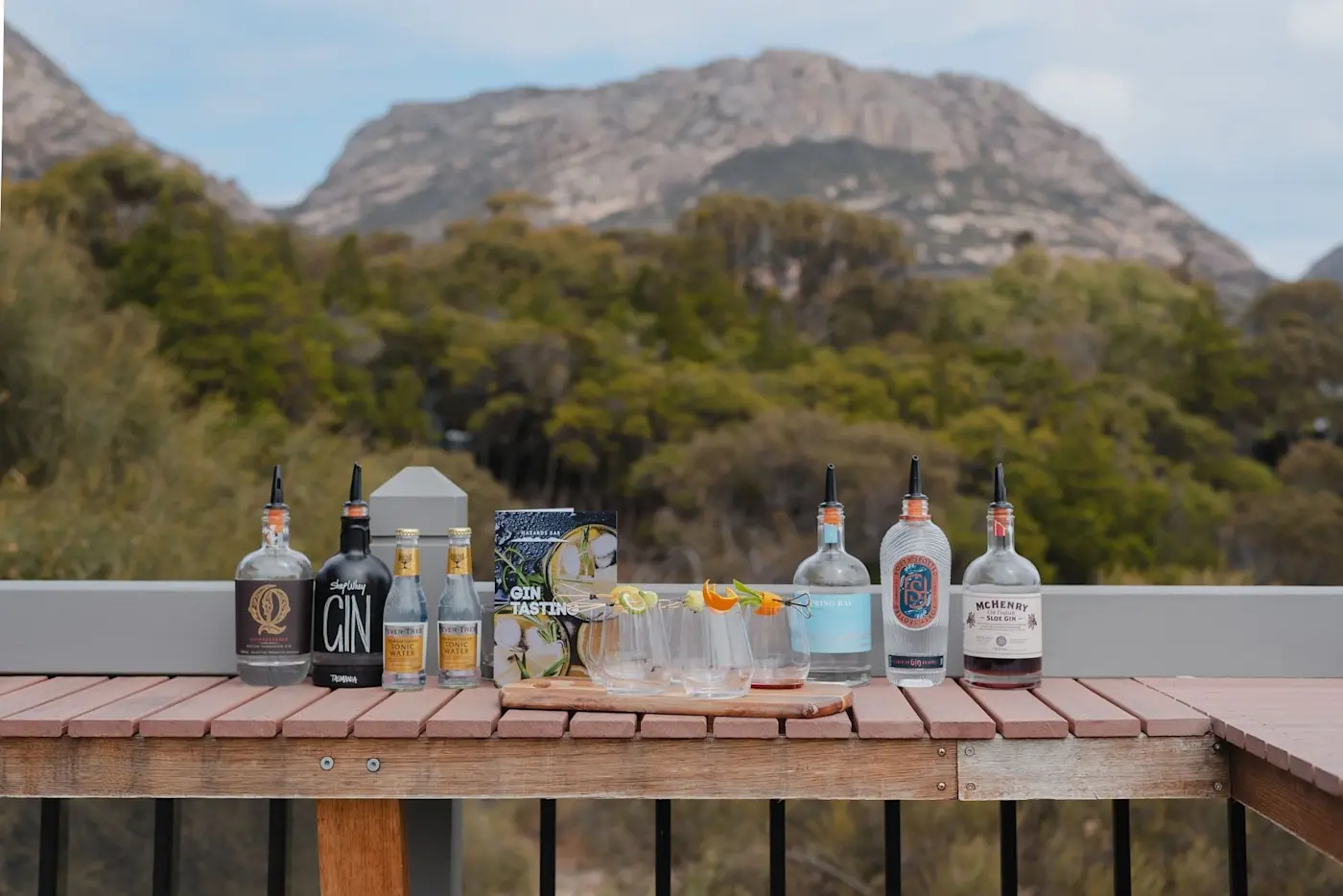Liquor bottles placed on a table with a mountain backdrop near Freycinet Lodge