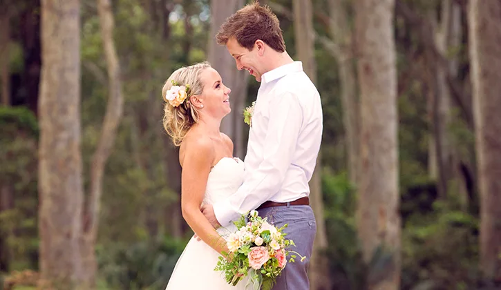 Bride and groom looking into each others eyes amongst the trees