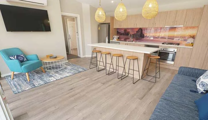 Kitchen, dining and lounge area of cabin at Tathra Beachfront Holiday Park