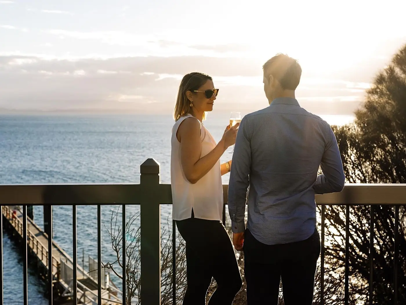 Couple enjoying wine overlooking from the balcony at Freycinet Lodge