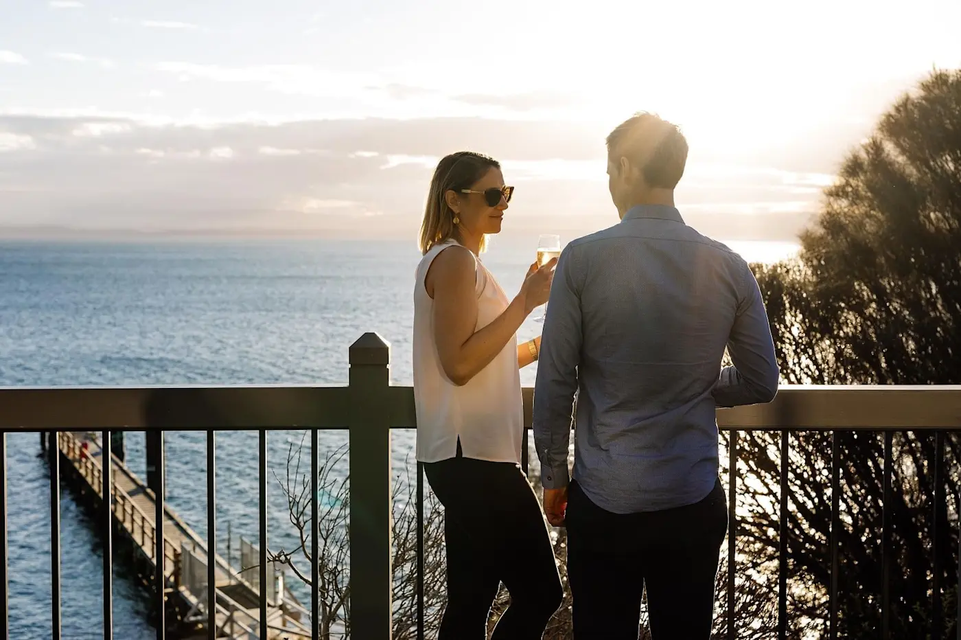 Couple enjoying wine overlooking from the balcony at Freycinet Lodge