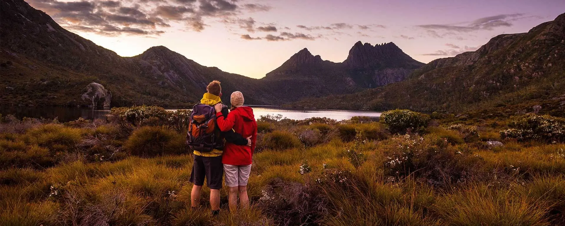 Couple overlooking the lake & mountains from a trail near Cradle Mountain Hotel