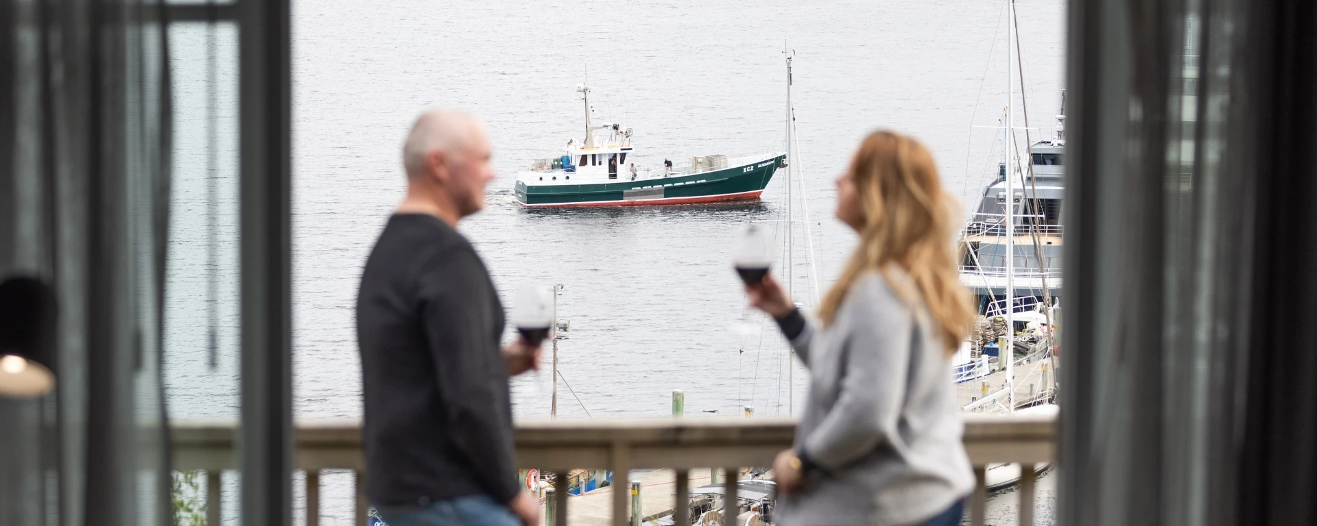Couple on Harbour View Room balcony at Strahan Village