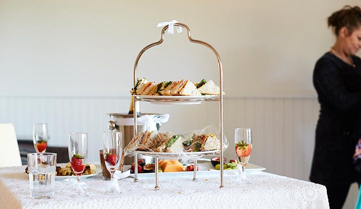 High tea table with sandwiches and champagne