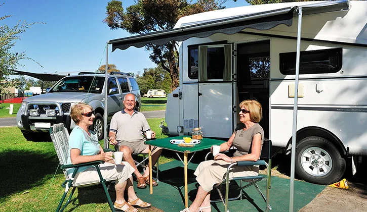 People sitting around a caravan in Lakes Entrance