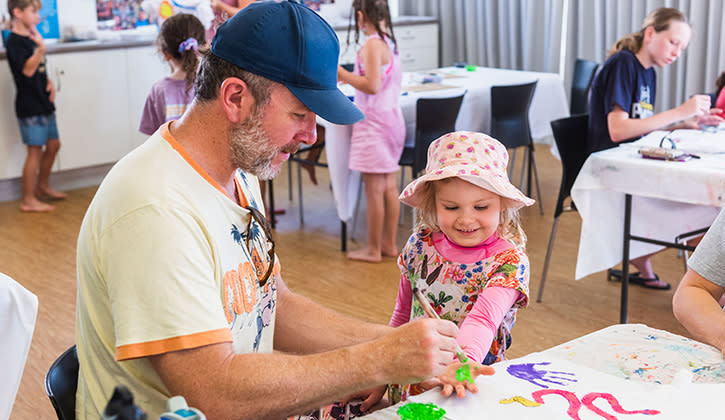 Man and child painting with their hands