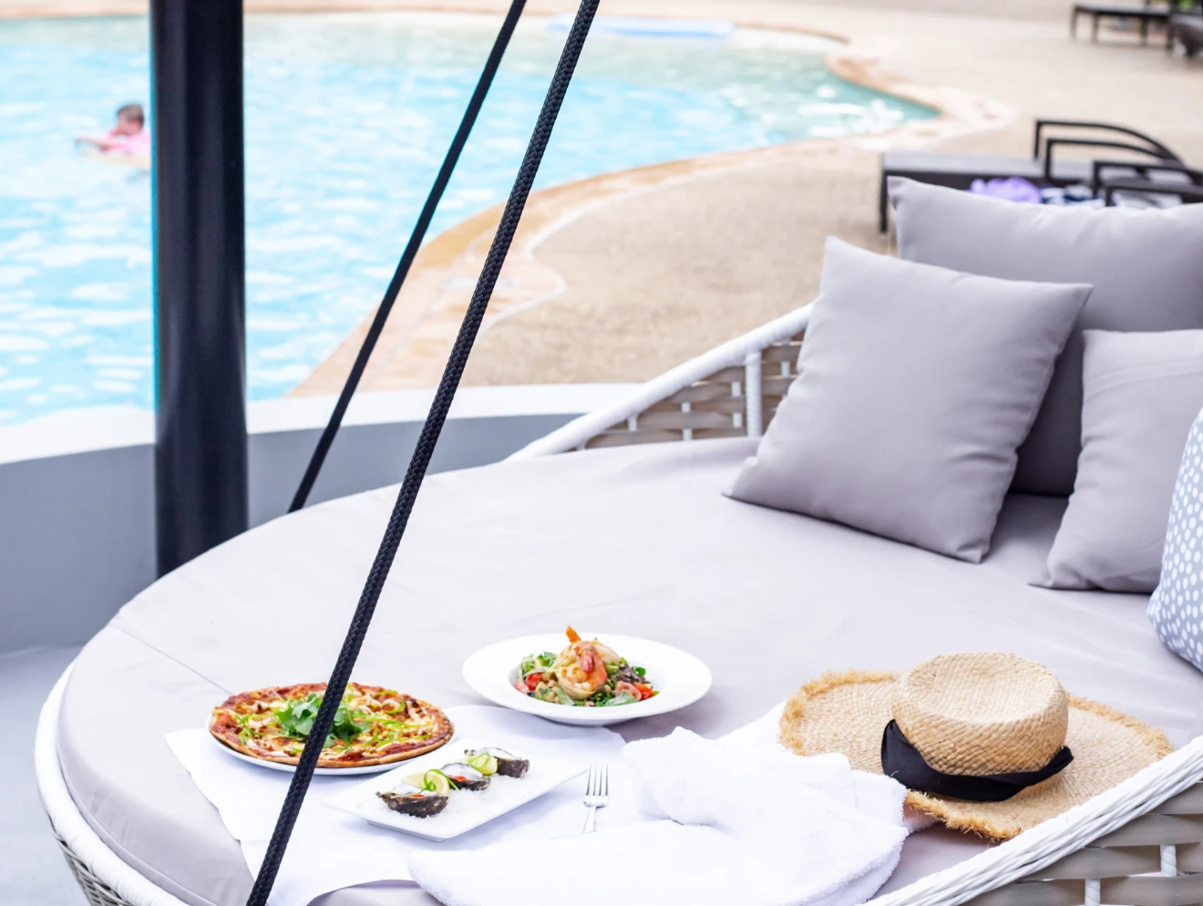 Dining poolside on a hanging daybed