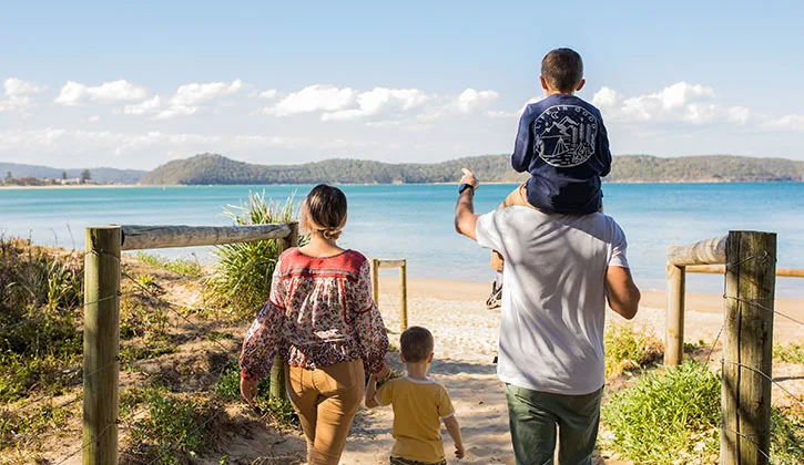 Family walking towards the ocean