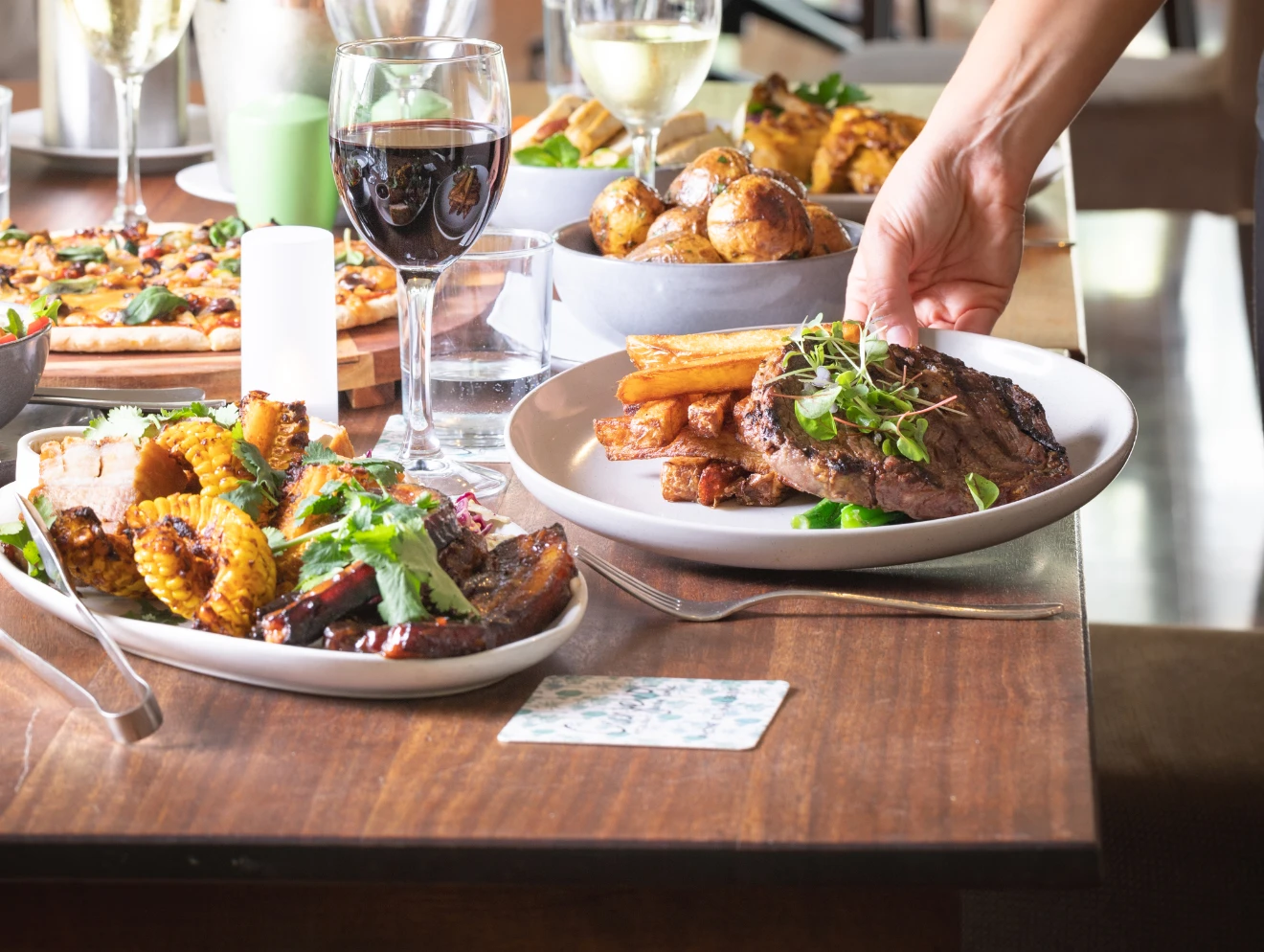 Waiter putting plate of food down on table