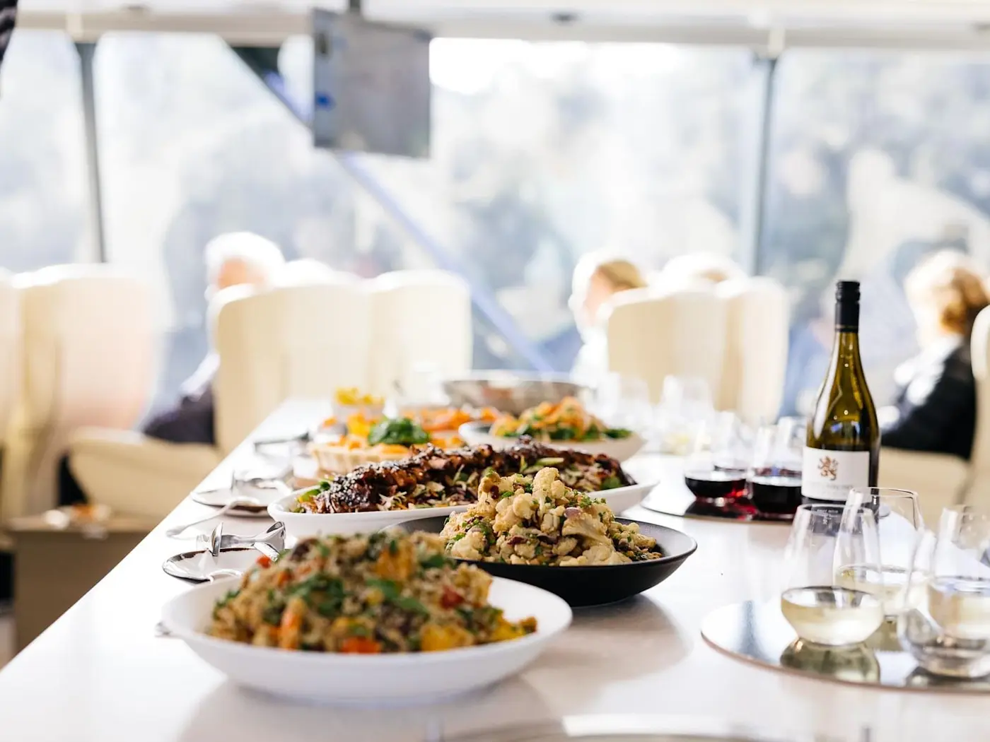 Champagne & dishes arranged on a table at Strahan Village