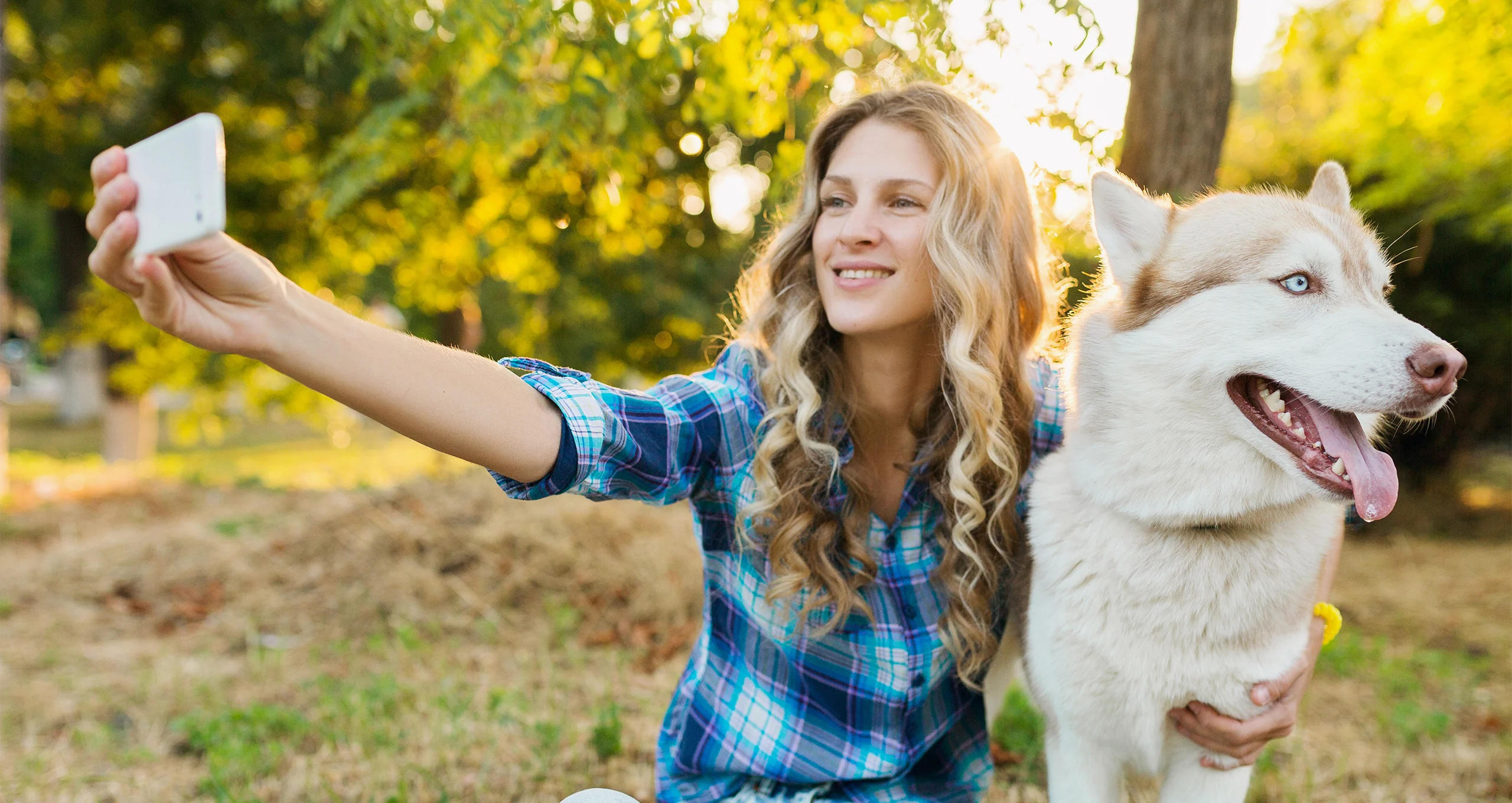 h woman in blue plaid shirt taking selfie with white shepard
