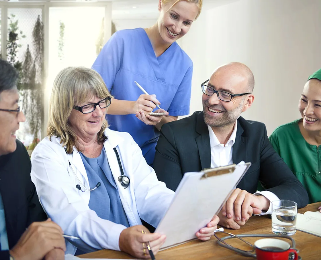 Veterinarian and two assistants meeting with clients at a table