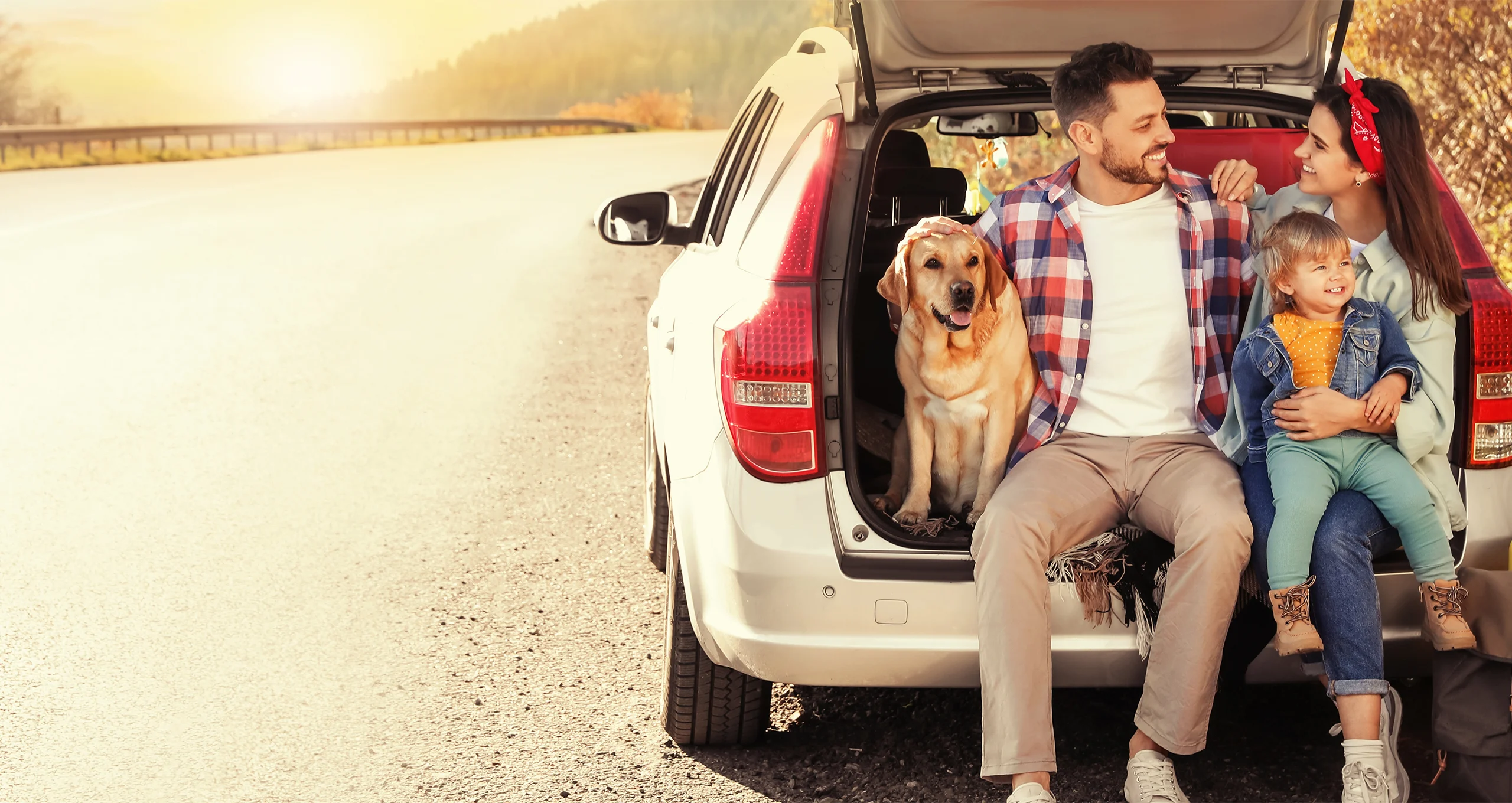 h family in back of suv at dawn dusk with yellow lab
