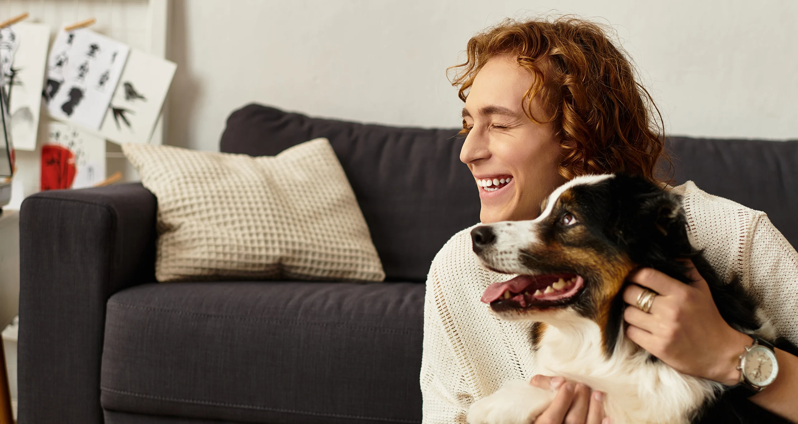 h man with mixed dog on couch in living room