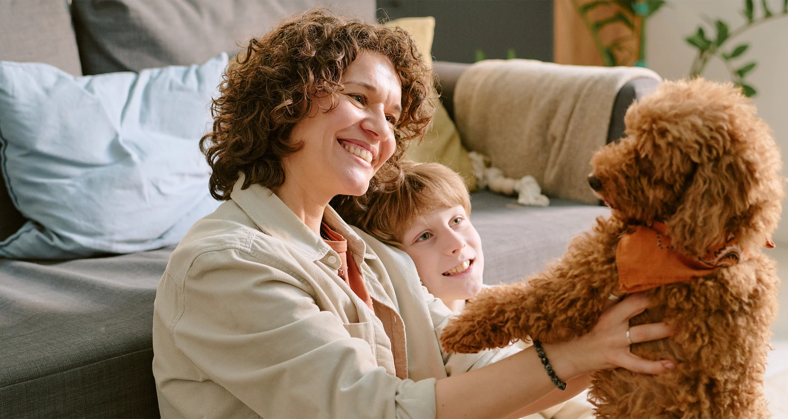 h woman with son on floor with dark red poodle