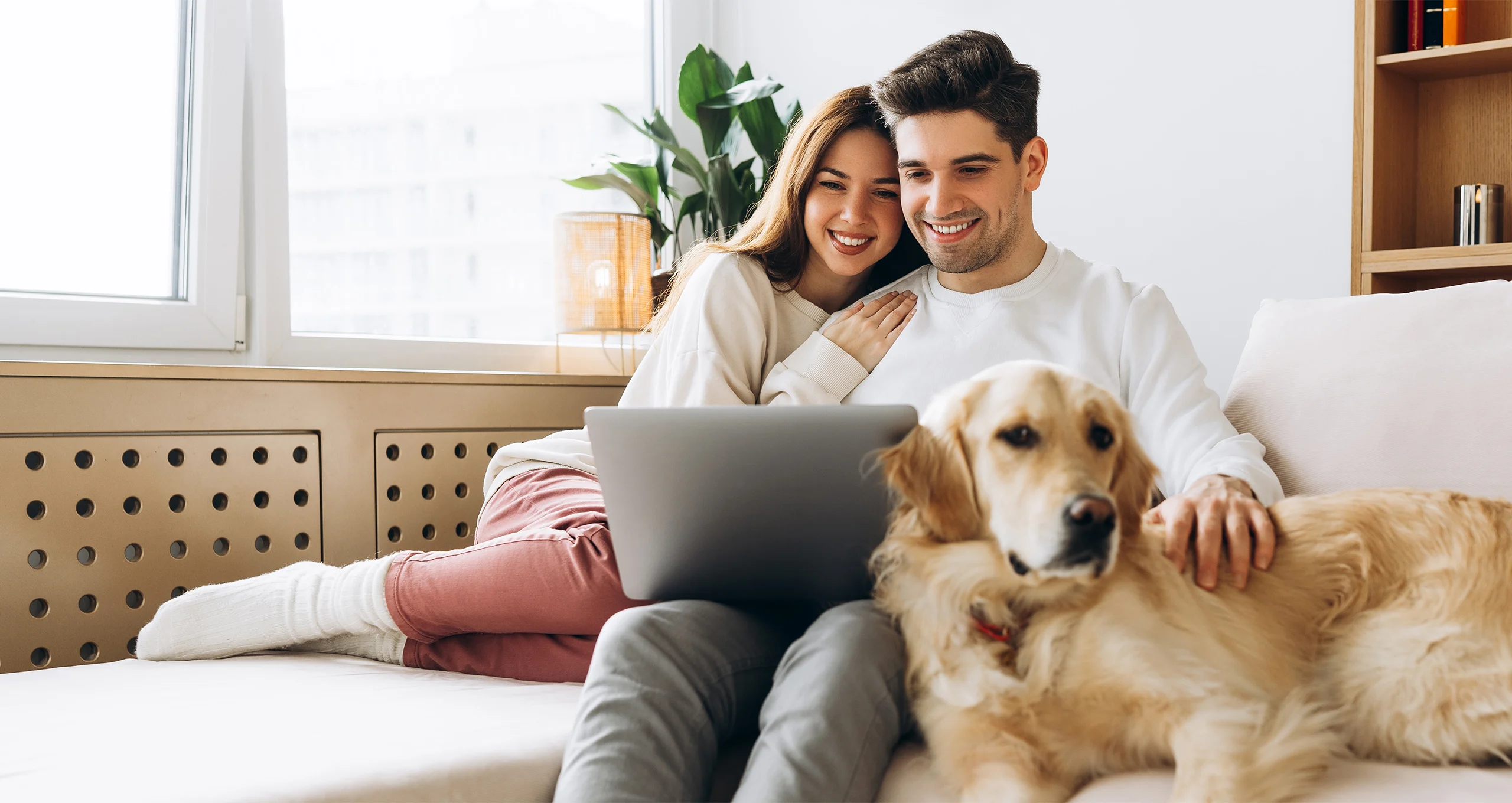 h man and woman on computer with golden near them
