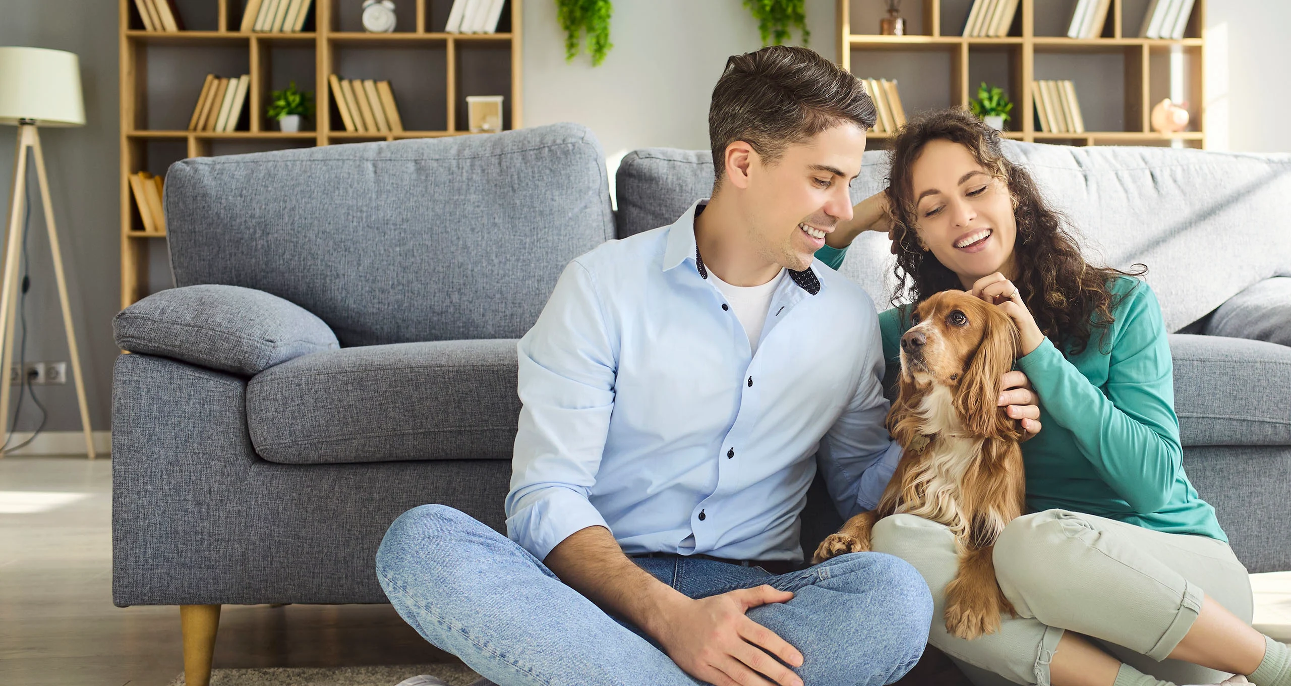 h Couple with cocker spaniel dog in front of couch at home