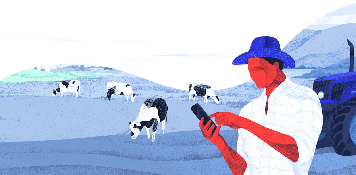 Farmer with phone with cattle in background