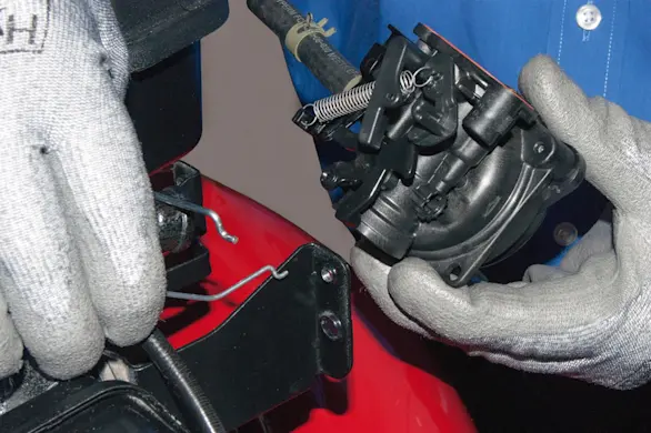 PHOTO: Remove the carburetor from the lawn mower.