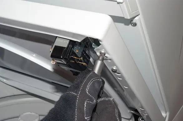 PHOTO: Remove the lid lock mounting screws.