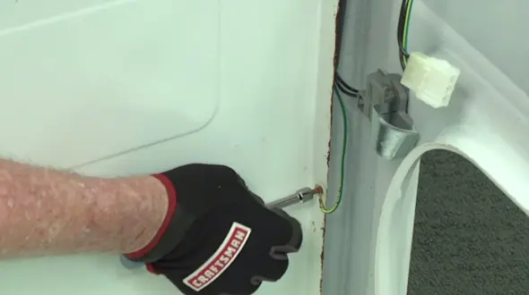 PHOTO: Remove the green ground wire from the washer cabinet.