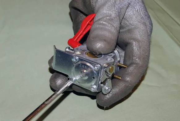 PHOTO: Remove the screws from the carburetor bottom cover.
