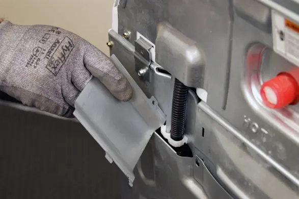 PHOTO: Remove the wire cover from the washer.