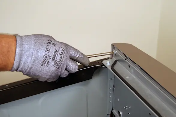 PHOTO: Remove the screw on the back of the control panel.